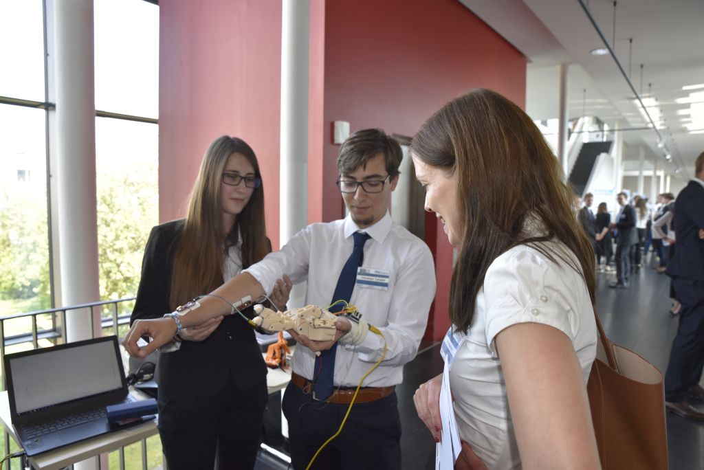 Anamaria and Cristian-Alexandru show a visitor how their hand prosthesis works. (Image: FAU/Christina Dworak)