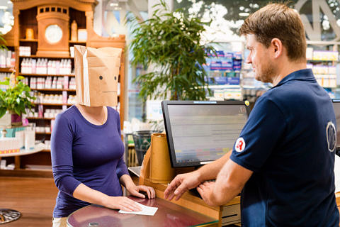 Zwei Personen, eine hat eine Tüte auf dem Kopf