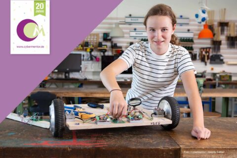 Junge Frau mit einem selbstgebautem Roboter.